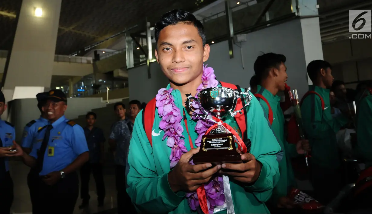 Pemain Timnas Indonesia U-16, Fadillah Nur Rahman menunjukkan trophy Jenesys saat penyambutan di Bandara Soetta, Tangerang, Kamis (15/2). Timnas Indonesia U-16 berhasil menjuarai turnamen Jenesys di Jepang. (Liputan6.com/Helmi Fithriansyah)
