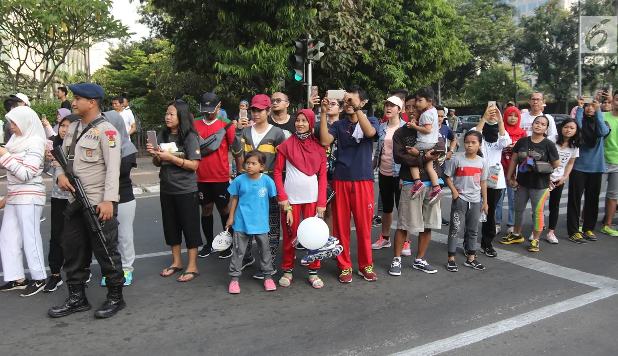 Antusias warga yang tengah mengikuti Car Free Day (CFD) menyaksikan Parade Asian Games 2018 2018 di Jalan Thamrin, Jakarta, Minggu (13/5). Parade Asian Games 2018 jadi pusat perhatian pengunjung Car Free Day. (Liputan6.com/Arya Manggala)