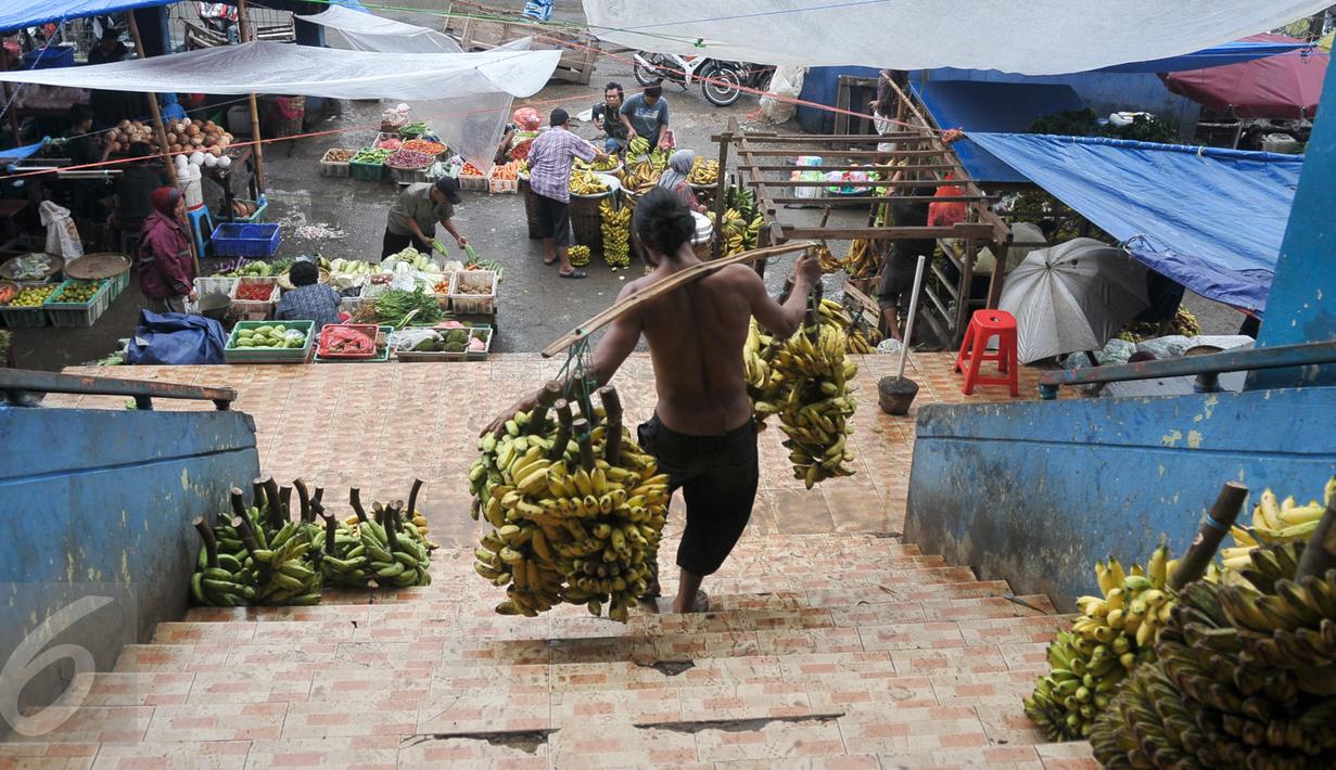 Seorang pria memanggul pisang sambil menuruni tangga pasar di Pasar Minggu, Jakarta, Senin (10/10). Gubernur DKI Basuki Tjahaja Purnama (Ahok) meminta PD Pasar Jaya mengambil alih pengelolaan pasar di Ibukota dari pihak ketiga. (Liputan6.com/Yoppy Renato)
