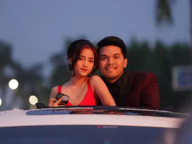 Fuji dan Thariq Halilintar saat berpose di mobil dengan atap terbuka. Keduanya begitu serasi dengan busana yang dikenakan, Fuji mengenakan dress berwarna merah sedangakan Thariq dengan setelan jas hitam. Fuji menggungah foto ini di akun Instagramnya dengan menulis pesan “Berjuang bersama sama terus ya be”.  (Instagram/fuji_an)