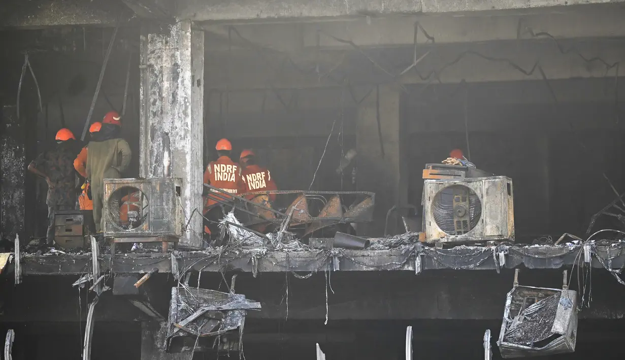 <p>Anggota Pasukan Tanggap Bencana Nasional dan petugas pemadam kebakaran memeriksa sebuah gedung komersial sehari setelah kebakaran terjadi di New Delhi, India, Sabtu (14/5/2022). Kebakaran yang melanda gedung perkantoran empat lantai di Delhi, pada Jumat 13 Mei 2022, menewaskan sedikitnya 27 orang dan melukai sedikitnya 12 orang, kata layanan darurat. (Sajjad HUSSAIN / AFP)</p>