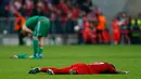 Bek Muenchen, David Alaba tergeletak di tengah lapangan usai pertandingan melawan Atletico Madrid di semifinal Liga Champions di Allianz Arena (4/5). Atletico melaju ke final dengan aggregat gol tandang. (Reuters/Ralph Orlowski)