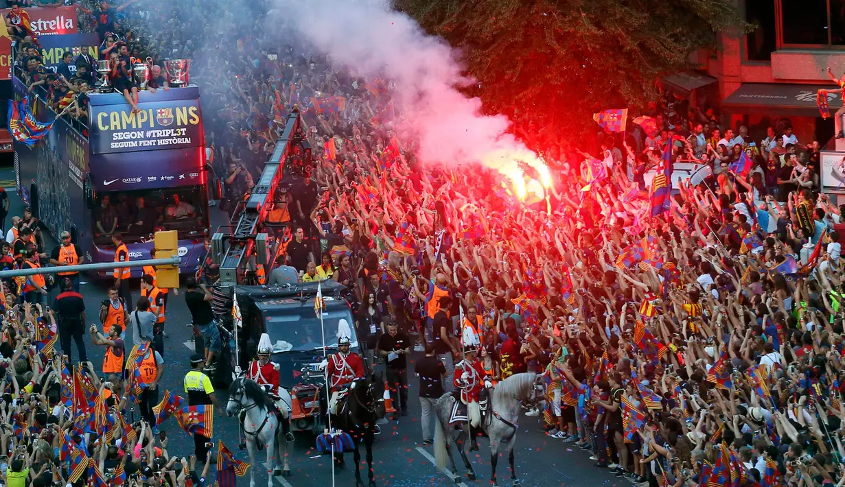 Para pemain Barcelona merayakan kemenangan bersama suporter dari atas bus saat melakukan parade di Barcelona, Spanyol (7/6/2015). Barcelona untuk kelima kalinya meraih piala liga Champions usai mengalahkan Juventus 3-1. (REUTERS/Albert Gea)
