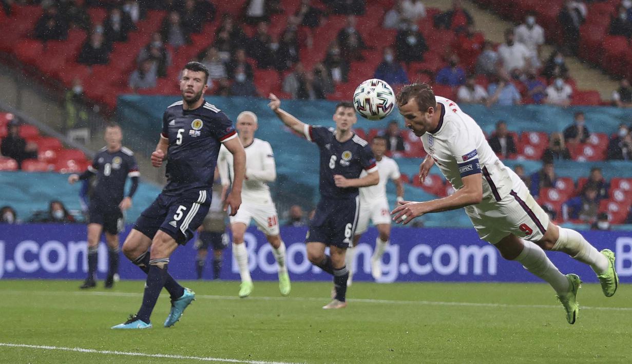 Pemain Timnas Inggris Harry Kane (kanan) menyundul bola saat pertandingan Grup D Euro 2020 antara Inggris melawan Skotlandia di stadion Wembley, London, Jumat, (18/6/2021). (AP/Pool/Carl Recine)