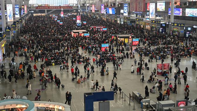 Padatnya Arus Mudik China: Penumpang menunggu jadwal keberangkatan mereka di Stasiun Kereta Hongqiao di Shanghai pada Senin (20/1/2020). China berada di tengah-tengah kesibukan migrasi manusia tahunan ketika jutaan orang pulang ke kampung halaman untuk menikmati libur Imlek. (HECTOR RETAMAL/AFP)