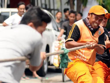 Petugas PPSU Kelurahan Kebon Sirih saat mengikuti lomba tarik tambang di kawasan Jalan Jaksa, Jakarta, Kamis (17/8). Lomba diadakan untuk memeriahkan HUT RI ke-72. (Liputan6.com/Helmi Fithriansyah)