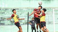 Pemain baru Arema, Mikael Tata diapit Hamdi Sula dan Seiya da Costa saat duel bola atas pada sesi latihan tim. (Iwan Setiawan/Bola.com)