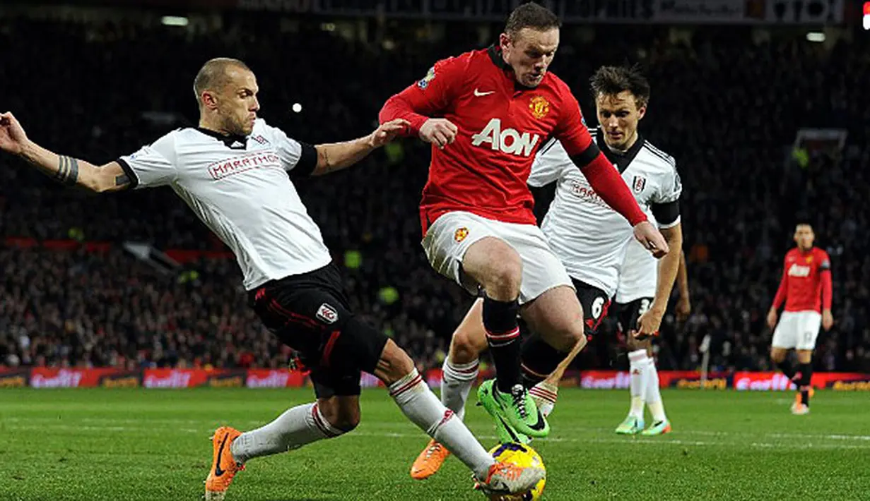 Bek Fulham asal Belanada John Heitinga (kiri) memberikan perlawanan kepada penyerang Manchester United Wayne Rooney saat laga pertandingan sepak bola Liga Premier Inggris antara Manchester United melawan Fulham di Old Trafford, Manchester, Minggu (9/2/14)
