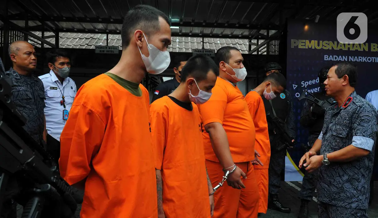 Direktur Pengawasan Tahanan dan Barang Bukti (Wastahti) Badan Narkotika Nasional (BNN) Samudi (kanan) berbincang dengan para tersangka saat pemusnahan barang bukti ganja di Lapangan Gedung BNN, Jakarta, Rabu (18/1/2023). BNN memusnahkan barang bukti 222,697 kilogram ganja dan menangkap empat tersangka berinisial AE alias Adul, RJ, MF, dan G yang merupakan narapidana Lapas Kelas I Tangerang dari pengiriman paket kargo di depan Mall Cijantung. (merdeka.com/Imam Buhori)
