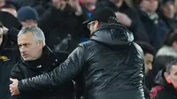 Manajer Manchester United, Jose Mourinho berjabat tangan dengan manajer Liverpool, Jurgen Klopp seusai pertandingan  lanjutan pekan ke-17 Premier League di Stadion Anfield, Minggu (16/12). MU tumbang di markas Liverpool dengan skor 1-3. (Paul ELLIS / AFP)