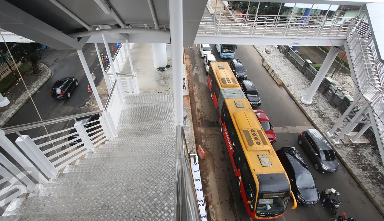 Bus Transjakarta melintas di bawah pembangunan Jembatan Penyeberangan Orang (JPO) halte layangTransjakarta CSW di Kebayoran Baru, Jakarta, Senin (9/1). JPO halte ini setara dengan bangunan empat lantai. (Liputan6.com/Immanuel Antonius)