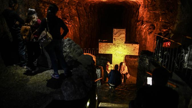 Gambar pada Agustus 2019 menujukkan wisatawan mengunjungi Katedral garam Zipaquira di 45 km sebelah utara Bogota, ibu kota Kolombia. Arsitektur gua di bawah memiliki tiga bagian yang menggambarkan kelahiran, kehidupan, dan kematian Yesus. (JUAN BARRETO/AFP)