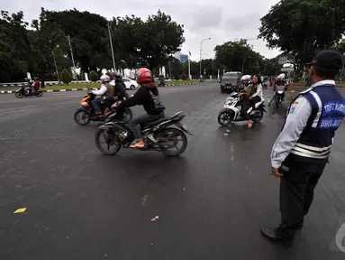 Sejumlah kendaraaan roda dua saat melintasi untuk memasuki kawasan monas, Jakarta, Kamis (1/1/2015). ( Liputan6.com/Miftahul Hayat)