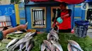Pedagang ikan bandeng melayani pembeli di Rawa Belong, Jakarta, Jumat (20/1/2023). Penjual bandeng musiman ini menjual daganganya jelang perayaan Imlek yang dijual dengan harga mulai dari Rp. 50.000 hingga Rp. 90.000 per kilonya. (Liputan6.com/Angga Yuniar)