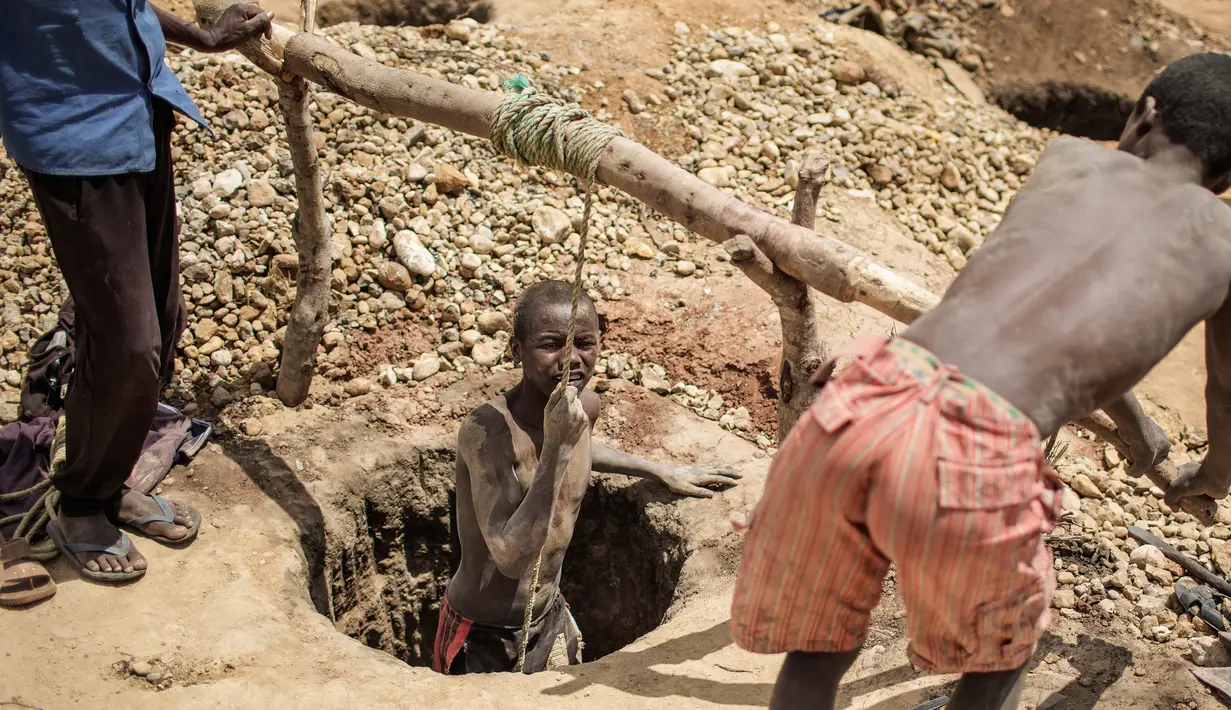Buruh tambang menarik rekannya keluar dari dalam lubang tambang usai mencari safir di kawasan pertambangan batu safir di Sakaraha, Madagaskar. (AFP Photo/Gianluigi Guercia)
