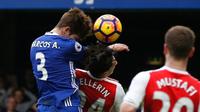 Pemain Chelsea Marcos Alonso unggul duel udara melawan bek Arsenal Hector Bellerin dan membuat bola masuk ke gawang Petr Cech pada laga di Stamford Bridge, London, Sabtu (4/2/2017). (AFP/Ian Kington)