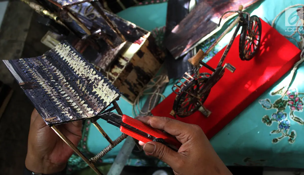 Perajin, Inoe Farhand melakukan finishing pengerjaan pembuatan miniatur jam dari pelepah pisang di Pamulang, Tangerang Selatan, Kamis (10/1). Kerajinan tangan Inoe hasilnya dijual ke sejumlah wiliyah JODETABEK hingga mancanegara. (Merdeka.com/Arie Basuki)