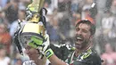 Kiper Juventus, Gianluigi Buffon, mengangkat trofi usai melawan Verona pada laga Serie A Italia di Stadion Allianz, Turin, Sabtu (19/5/2018). Laga ini menjadi yang terakhir bagi Buffon setelah 17 tahun membela Juventus. (AFP/Andreas Solaro)