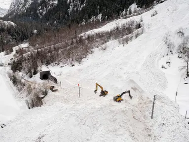 Ekskavator dikerahkan untuk memulihkan jalur kereta api antara Visp dan Taesch yang terputus akibat longsoran salju, Swiss, (10/1). Bencana tersebut menyebabkan terputusnya jalur kereta api dan seluruh akses menuju Zermatt. (AFP Photo/Fabrice Coffrini)