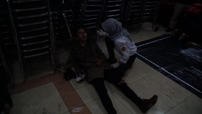 Salah seorang peserta aksi demonstrasi di depan Gedung DPRD Jabar mengalami sesak napas usai mendapatkan gas air mata. (Liputan6.com/Huyogo Simbolon)