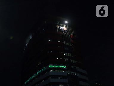 Aktivis Greenpeace menembakkan sinar laser bertuliskan Mosi Tidak Percaya ke gedung Merah Putih KPK, Jakarta, Senin (28/6/2021) malam. Aksi tersebut sebagai bentuk keprihatinan atas upaya pelemahan KPK sejak disahkannya Revisi UU KPK hingga Tes Wawasan Kebangsaan. (Liputan6.com/Helmi Fithriansyah)