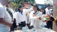 Menteri BUMN Rini Soemarno yang ikut berbelanja dan mencicipi jajanan di pasar murah yang diadakan oleh Pertamina untuk warga Lima Puluh, Pekanbaru.