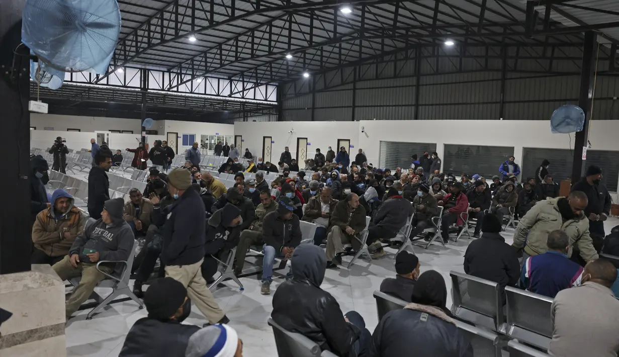 Pekerja Palestina menunggu di stasiun terakhir di Beit Hanun di Jalur Gaza utara, sebelum mencapai Israel melalui penyeberangan Erez untuk bekerja (23/2/2022). Israel mengatakan akhir tahun lalu bahwa 3.000 warga Gaza tambahan akan diizinkan masuk Israel untuk bekerja. (AFP/Mohammed Abed)