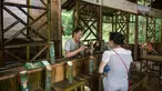 Pengunjung memesan minuman alkohol yang disimpan di dalam batang bambu di Hutan Yibin, China pada 30 Juli 2016. Minuman hasil frementasi biasanya disimpan di tong kayu, namun berbeda dengan minuman beralkohol buatan Chen Chao. (AFP Photo/Fred Dufour)
