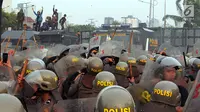 Polisi menghalau mahasiswa dalam demonstrasi menolak pengesahan RUU KUHP dan revisi UU KPK di depan Gedung DPR, Jakarta, Selasa (24/9/2019). Polisi menghalau mahasiswa yang berusaha masuk ke area Gedung DPR. (Liputan6.com/JohanTallo)