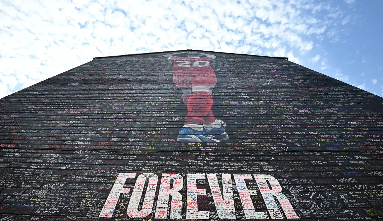 Mural penghormatan bergambar mendiang Diogo Jota yang tengah membuat simbol hati dengan tangannya terlihat di dinding perumahan dekat Stadion Anfield, Liverpool, Inggris, Senin (11/08/2025) waktu setempat. Karya tersebut dibuat oleh seniman bernama MurWalls. (AFP/Paul Ellis)