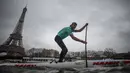 Peserta Nautic Paddle Race atau lomba dayung sambil berdiri melintas dekat Menara Eiffel di Sungai Seine, Paris, Minggu (8/12/2019). Sekitar 1000 pesaing ikut serta dalam lomba sejauh 11 kilometer menyeberangi sungai Seine dengan pemandangan kota Paris. (Photo by Olivier MORIN / AFP)
