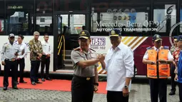 Menteri Perhubungan Budi Karya Sumadi melakukan salam komando dengan Kapolri Jenderal Tito Karnavian saat meresmikan Operasi Green Line dan pelepasan Bus TransJabodetabek Premium di Mega City, Bekasi Barat, Senin  (12/3). (Liputan6.com/Arya Manggala)