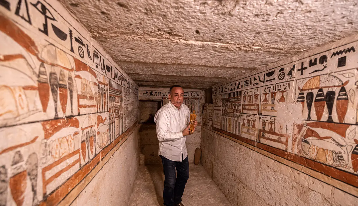 Kepala Dewan Tertinggi Kepurbakalaan Mesir, Mostafa Waziri memegang patung kecil di makam Henu, salah satu dari lima makam Firaun kuno di situs arkeologi Saqqara, Kairo, Mesir (19/3/2022). Menurut Waziri, lima makam yang semuanya dalam kondisi baik itu milik petinggi kerajaan. (AFP/Khaled Desouki)