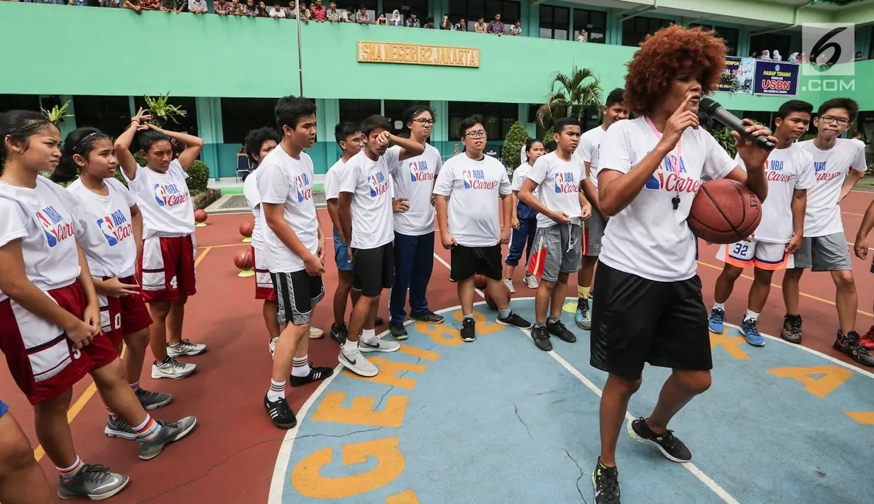 Pelatih memberi arahan pada program coaching clinic dan NBA Cares yang digelar Jr. NBA Indonesia di SMAN 82 Jakarta (28/9). Jr. NBA mengajarkan keterampilan dasar dan nilai-nilai yaitu Sportsmanship, Teamwork, a positive Attitude, dan Respect, atau disingkat (S.T.A.R.). (Liputan6.com/Fery Pradolo)