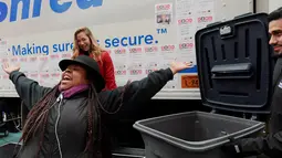 Seorang wanita bereaksi setelah melemparkan kertas berisi pesan yang ingin disobeknya pada acara "Good Riddance Day" di Times Square, New York, Rabu (28/12). Perayaan itu menjadi tradisi menghapus kenangan buruk selama satu tahun. (REUTERS/Darren Ornitz)