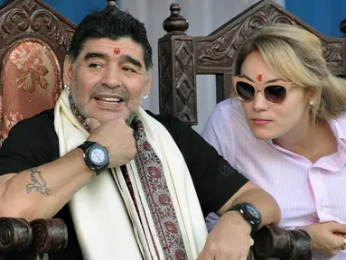 Legenda sepak bola Argentina Diego Maradona bersama istrinya  saat berkunjung di Kolkata, India (11/12). Maradona melakukan kunjungan pribadi ke India bersama sang istri. (AFP Photo)