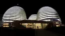 Seorang pengunjung saat berjalan didepan gedung Galaxy Soho yang baru dibuka rancangan arsitek Irak - Inggris Zaha Hadid di Beijing 27 Oktober 2012. (REUTERS / Jason Lee)