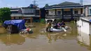 Para pemuda mengevakuasi warga saat banjir menggenangi kawasan RT 02/06, Kelurahan Petir, Kota Tangerang, Banten, Selasa (8/7/2025). (merdeka.com/Arie Basuki)
