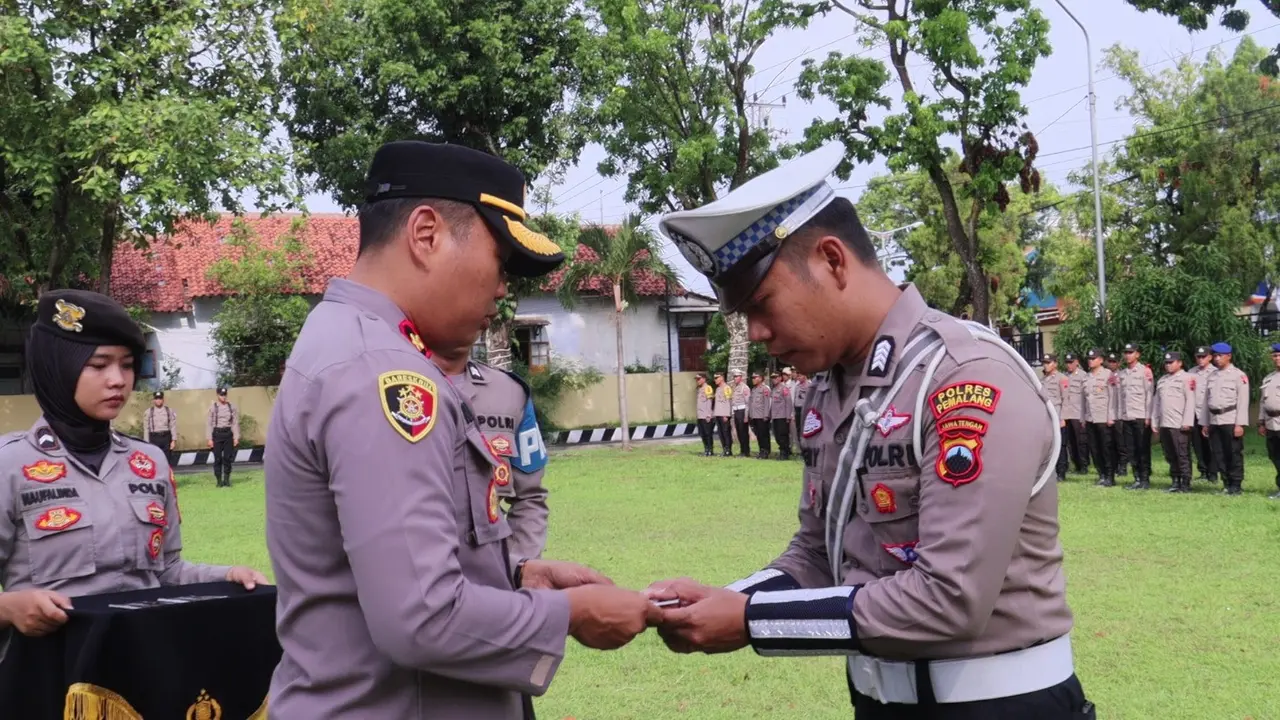 Wakapolres Pemalang membagikan buku saku pedoman jelang Pemilu 2024 untuk menjaga netralitas Polri. (Foto: Liputan6.com/Humas Polres Pemalang)