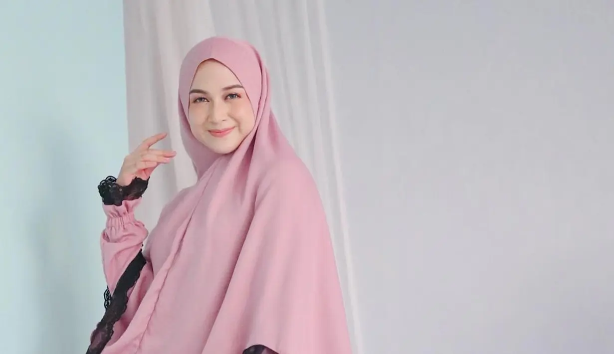Tak hanya pashmina dan jilbab segi empat, Nina Zatulini juga sering kenakan hijab syari. Tampil dengan hijab dan gamis berwarna senada, istri Chandra Taupan Ansar ini makin menawan. Senyuman yang dilemparkannya ke kamera membuat Nina Zatulini kian memesona. (Liputan6.com/IG/@ninazatulini22)
