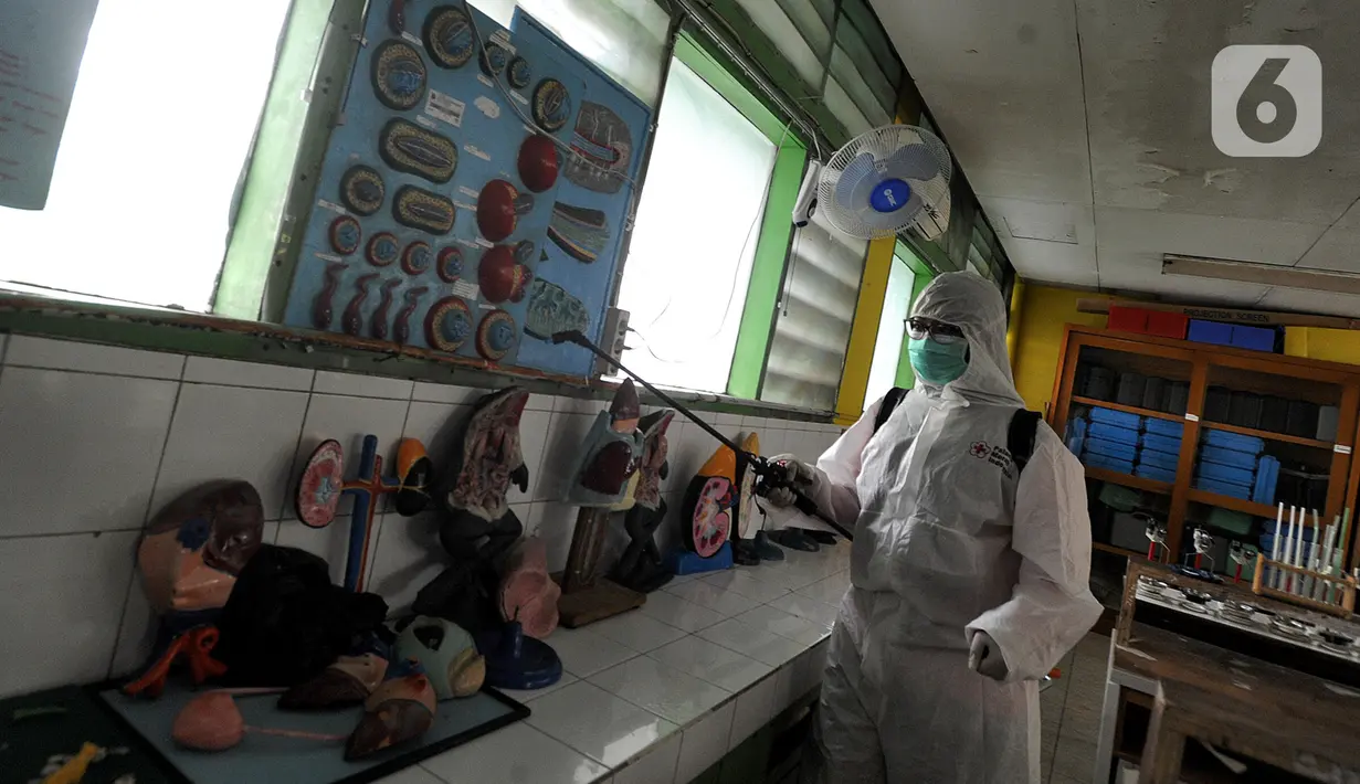 Petugas Palang Merah Indonesia (PMI) melakukan penyemprotan disinfektan di SMPN 216 Jakarta, Senin (16/3/2020). Mulai hari ini, aktivitas sekolah di sejumlah wilayah Indonesia diliburkan untuk mengantisipasi penyebaran virus corona COVID-19. (merdeka.com/Arie Basuki)