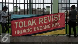 Demonstran dari Koalisi Masyarakat Sipil Antikorupsi dan Musisi menggelar Aksi memasang spanduk di Depan gedung DPR, Jakarta, Rabu (17/2/2016). Dalam aksinya mereka menuntut  "Tolak Revisi UU KPK".(Liputan6.com/Johan Tallo)