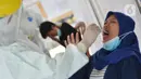 Petugas medis mengambil sampel lendir saat tes swab PCR massal di Kantor Kecamatan Pancoran Mas, Depok, Selasa (5/1/2021). Puskesmas Pancoran Mas melakukan tes Swab PCR kepada warga yang pernah memiliki riwayat kontak erat dengan pasien terkonfirmasi positif Covid-19. (merdeka.com/Arie Basuki)