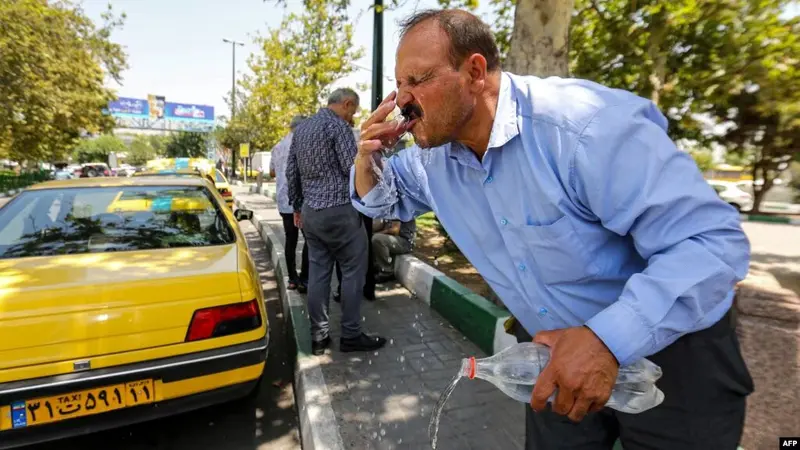 Seorang pria di Teheran mencuci muka pada Selasa (11/7/2023) di tengah cuaca panas ekstrem yang terjadi di Iran. (Foto: AFP)