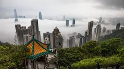 Orang-orang berkumpul di sudut pandang Peak untuk menyaksikan kabut di atas Hong Kong, Selasa (22/3/2022). Kabut tebal menyelimuti Hong Kong pada musim semi ketika wilayah tersebut dipengaruhi oleh udara dingin dan hangat bergantian. (AFP/Dale De La Rey)