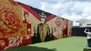 Pengunjung mengambil gambar mural yang dibuat oleh seniman Shepard Fairey di kawasan Wynwood, Miami, Florida pada 28 September 2016. Goldman Properties menggelar pameran mural untuk merevitalisasi lingkungan. (AFP PHOTO / Rhona WISE)