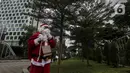 Pria berkostum Sinterklas berjalan saat membagikan kopi gratis kepada warga di kawasan Jalan Jenderal Sudirman, Jakarta, Sabtu (19/12/2020). Selain menyambut Natal, pembagian kopi tersebut juga untuk mempromosikan produk unggulan para petani di Indonesia. (Liputan6.com/Johan Tallo)