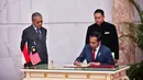 Presiden Joko Widodo menandatangani dokumen disaksikan Perdana Menteri Malaysia Mahathir Mohamad di Putrajaya (8/8/2019). Pertemuan juga membahas masalah WNI di Malaysia hingga kelapa sawit dan kedua pemimpin tersebut akan salat Jumat bersama. (Farhan Abdullah/Department Of Information/AFP)