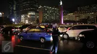 Petugas mengatur lalu lintas di kawasan Bunderan HI, Jakarta, Senin (18/4/2016). Akibat hujan mengguyur Jakarta hampir 2 jam, Lalu lintas Jalan Thamrin mengarah Sudirman macet mengular.(Liputan6.com/Faizal Fanani)