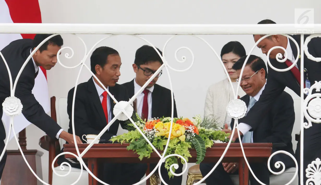 Petugas menyiapkan teh untuk menemani Presiden Joko WIdodo (Jokowi) dan PM Republik Demokratik Rakyat Laos Thongloun Sisoulith berbincang santai di Beranda Istana Bogor, Jawa Barat, Kamis (12/10). (Liputan6.com/Angga Yuniar)